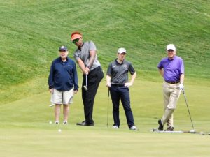 People playing golf on a sunny day.